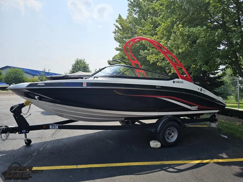 Slide: The Image of 2019 Yamaha AR195 boat on trailer, black with red accents, parked outdoors. - 18