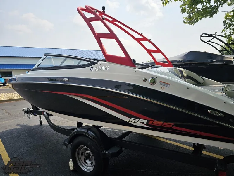 Slide: The Image of 2019 Yamaha AR195 boat with red accents on a trailer, parked outdoors. - 26
