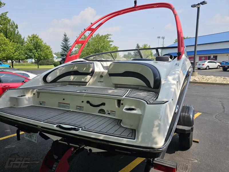 Slide: The Image of 2019 Yamaha AR195 boat on trailer, featuring red wakeboard tower and spacious rear deck. - 32