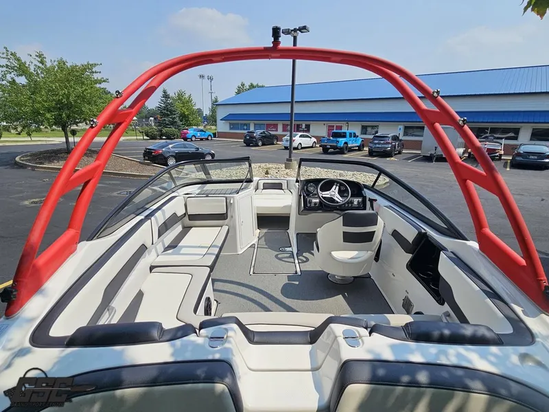 Slide: The Image of 2019 Yamaha AR195 boat interior with red wakeboard tower, parked near dealership. - 37