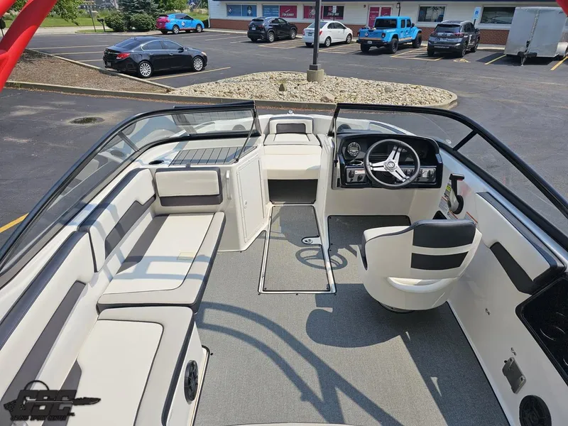 Slide: The Image of 2019 Yamaha AR195 boat interior with seating and steering wheel in a parking lot. - 39