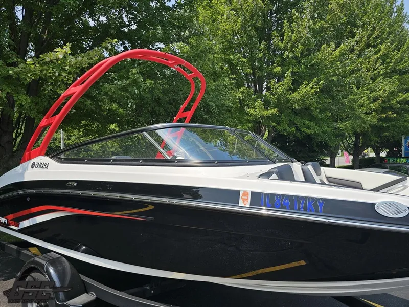 Slide: The Image of 2019 Yamaha AR195 boat with red tower, parked near trees. - 4