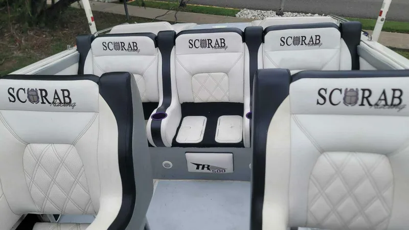 Slide: The Image of 1996 Wellcraft SCARAB boat interior with white and black seating, embroidered logos. - 10