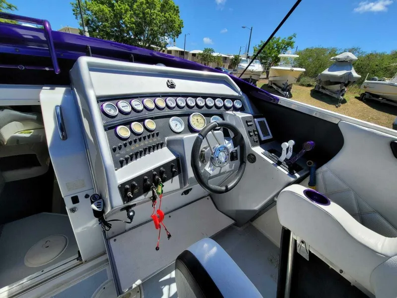 Slide: The Image of 1996 Wellcraft SCARAB boat cockpit with steering wheel and control panel. - 11