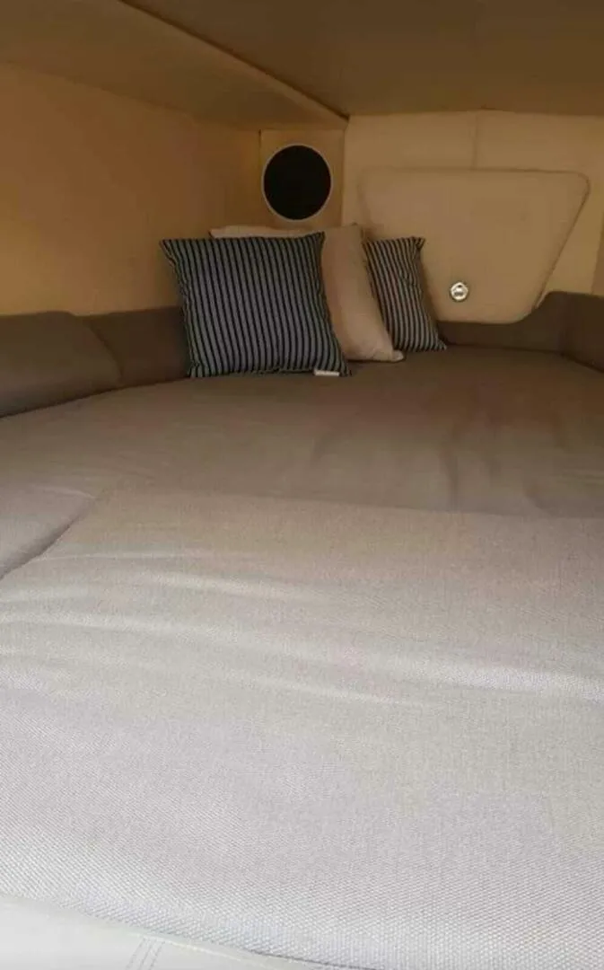 Slide: The Image of Interior cabin of 1996 Wellcraft SCARAB with cushioned bed and striped pillows. - 14