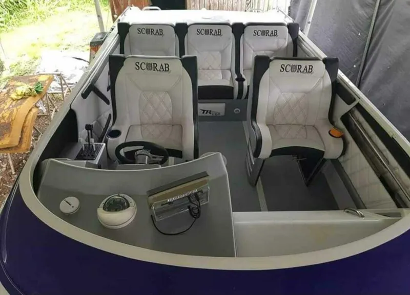 Slide: The Image of 1996 Wellcraft SCARAB boat interior with white seats and steering wheel. - 15