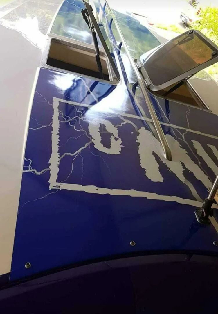 Slide: The Image of 1996 Wellcraft SCARAB boat with blue and white lightning graphics on the deck. - 16