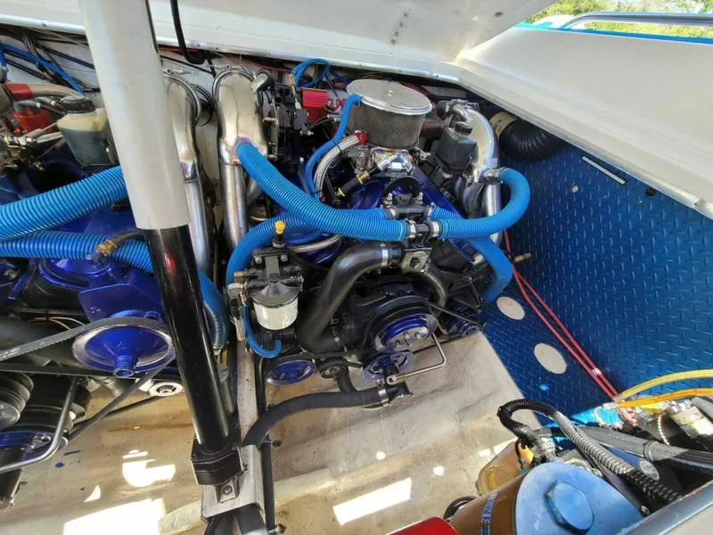 Slide: The Image of Engine compartment of a 1996 Wellcraft SCARAB boat with blue hoses and components. - 19