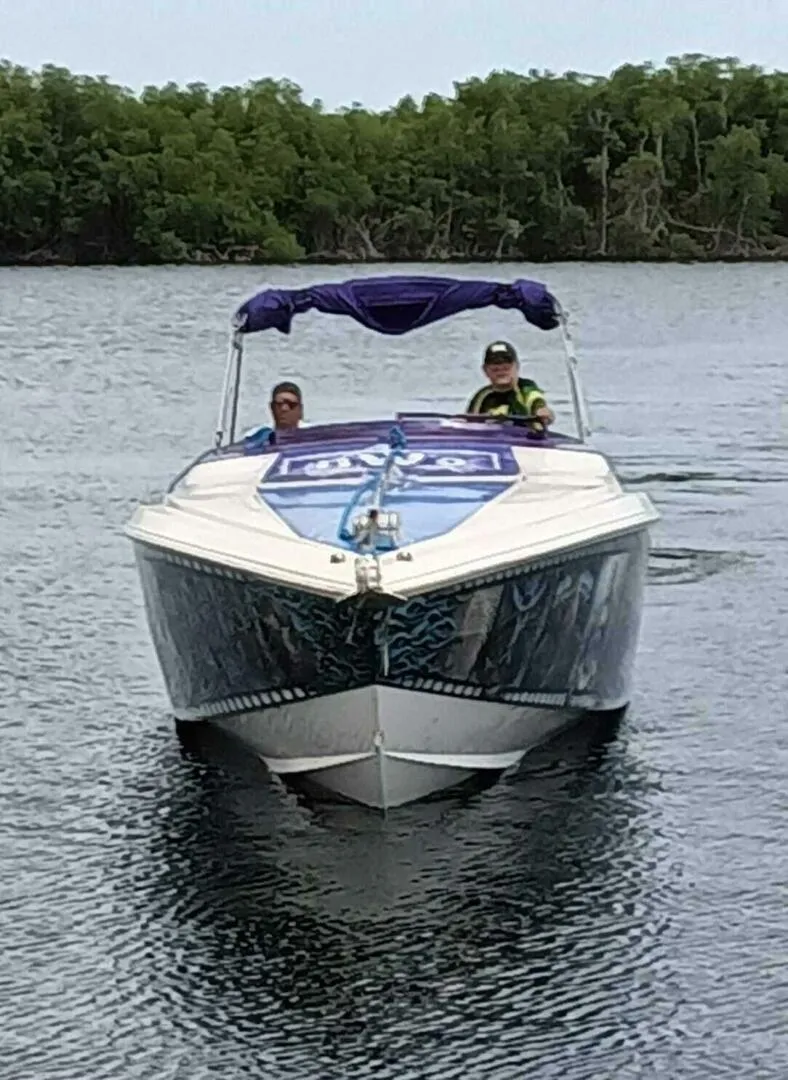 Slide: The Image of 1996 Wellcraft SCARAB boat on water with two people onboard, surrounded by trees. - 6