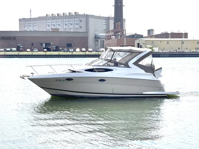 The Image of 2013 Regal 30 Express boat on water near industrial buildings. - 0