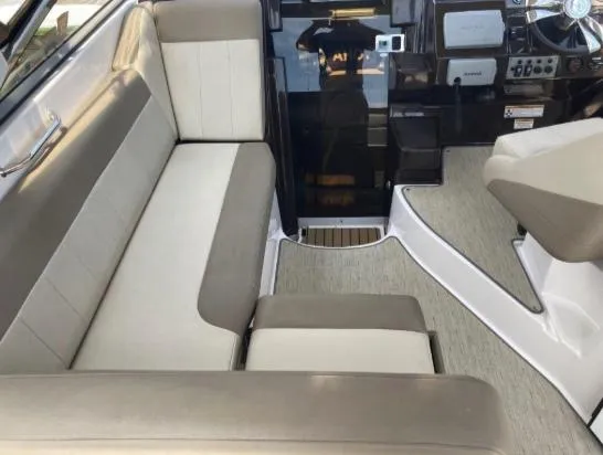 Slide: The Image of Interior of 2013 Regal 30 Express boat with beige seating and modern dashboard. - 10