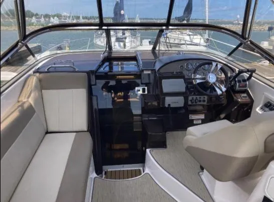 Slide: The Image of 2013 Regal 30 Express boat interior with steering wheel and seating area. - 12