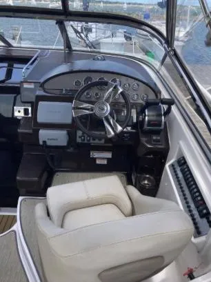 Slide: The Image of 2013 Regal 30 Express boat cockpit with steering wheel and control panel. - 14