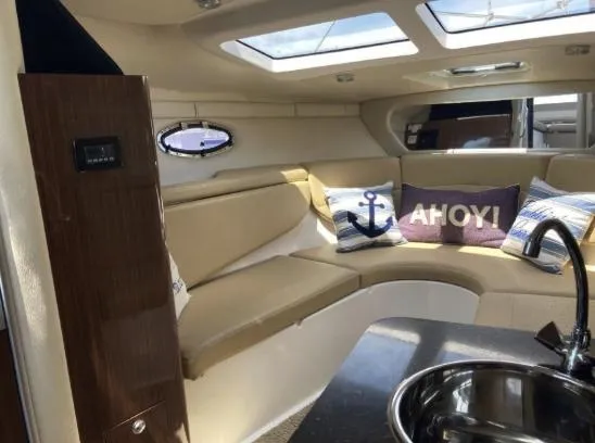 Slide: The Image of Interior of 2013 Regal 30 Express boat with cozy seating and nautical decor. - 15