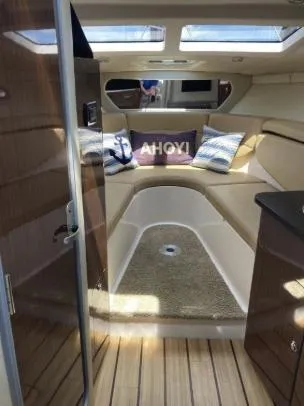 Slide: The Image of 2013 Regal 30 Express cabin interior with cozy seating and decorative pillows. - 16