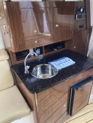 Slide: The Image of 2013 Regal 30 Express boat interior with kitchenette, sink, and storage cabinets. - 20