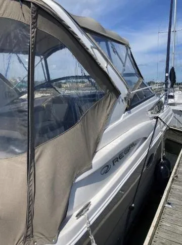 Slide: The Image of 2013 Regal 30 Express boat docked, featuring a beige canopy and sleek design. - 7