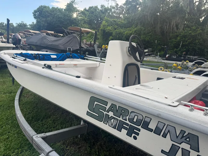 Slide: The Image of 2009 Carolina Skiff JV15CC boat on trailer, surrounded by greenery and other boats. - 4