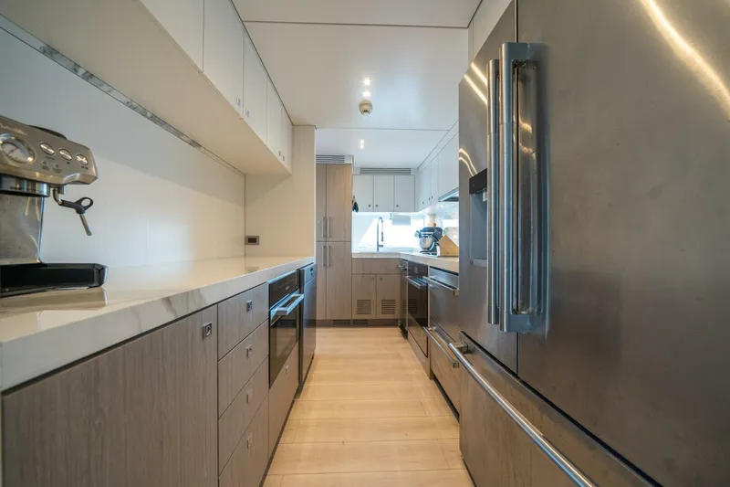 Slide: The Image of Modern kitchen interior on 2020 Hargrave C92 yacht, featuring stainless steel appliances and sleek cabinetry. - 20