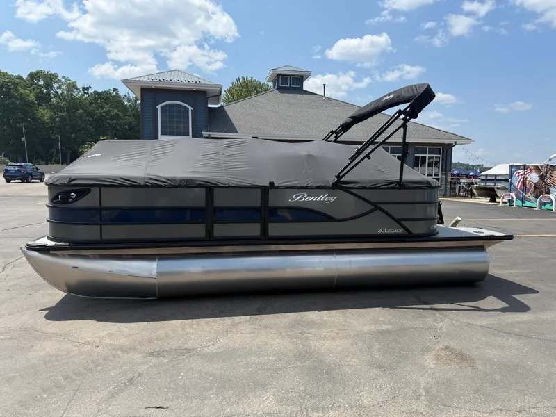 The Image of 2026 Bentley Pontoons Legacy 200 Navigator, covered, parked outdoors under a clear sky. - 0