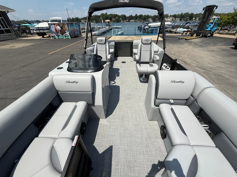 Slide: The Image of 2026 Bentley Pontoons Legacy 200 Navigator with spacious seating, docked by a scenic lake. - 8