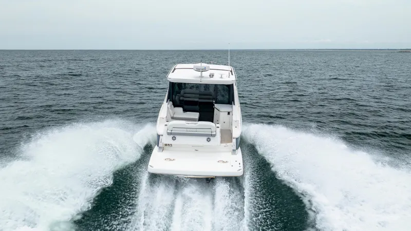 Slide: The Image of 2022 Regal 36 Grande Coupe cruising on open water, rear view. - 11