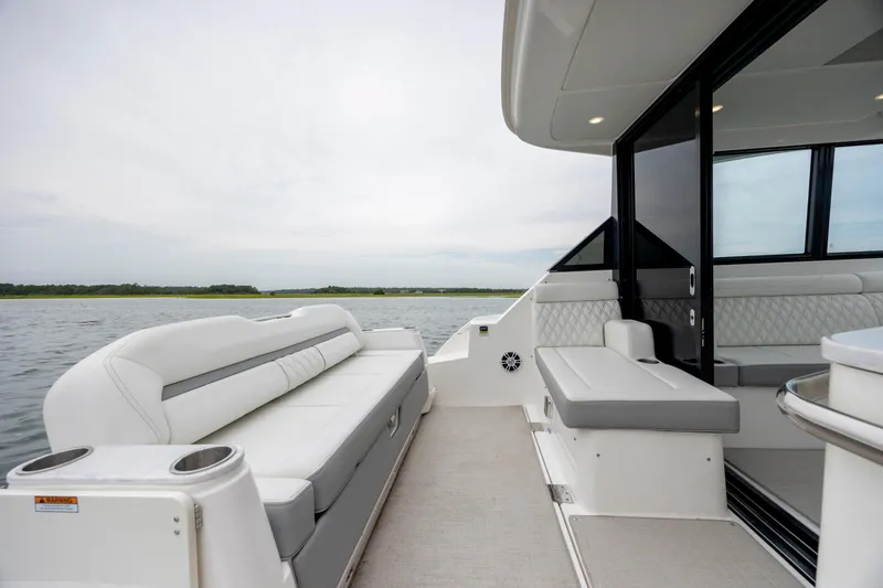 Slide: The Image of 2022 Regal 36 Grande Coupe boat interior with luxurious seating and scenic water view. - 16