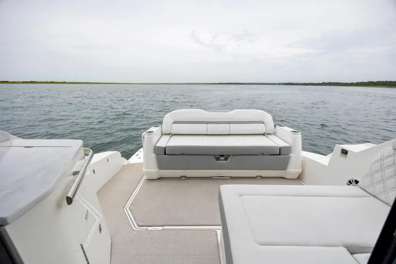 Slide: The Image of 2022 Regal 36 Grande Coupe boat interior with luxurious seating and scenic water view. - 17