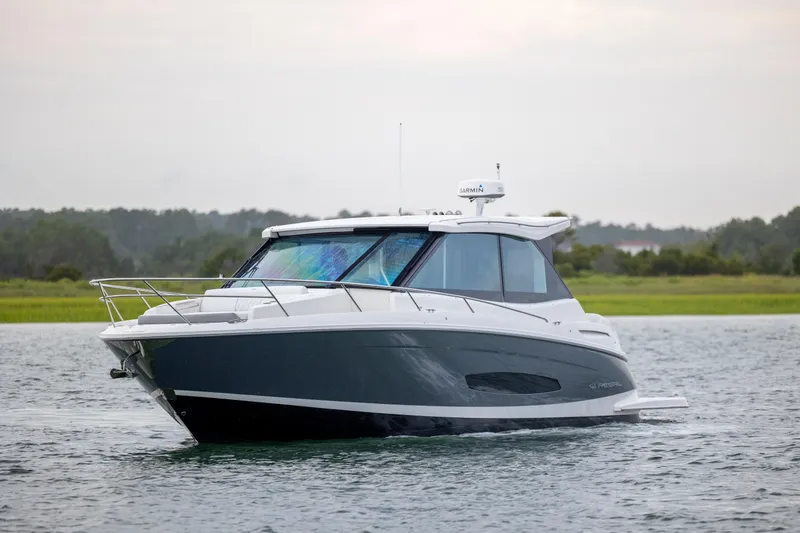 Slide: The Image of 2022 Regal 36 Grande Coupe boat cruising on calm water. - 2