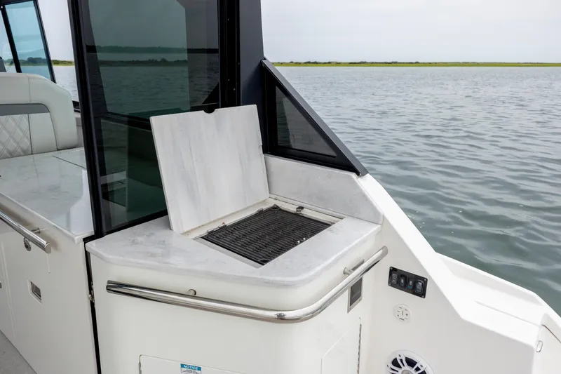 Slide: The Image of Outdoor grill on 2022 Regal 36 Grande Coupe yacht, overlooking serene water. - 20