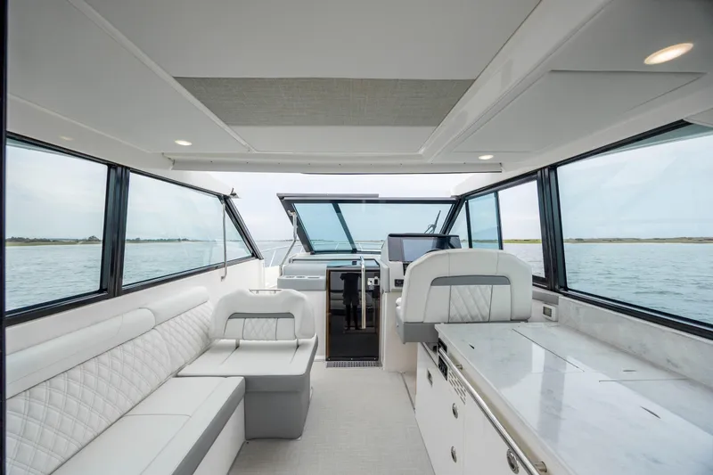 Slide: The Image of Interior of 2022 Regal 36 Grande Coupe yacht with luxurious seating and panoramic windows. - 23