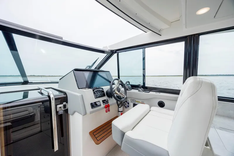Slide: The Image of 2022 Regal 36 Grande Coupe helm with modern controls and panoramic water view. - 30