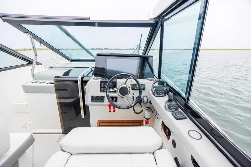 Slide: The Image of 2022 Regal 36 Grande Coupe helm with modern controls and panoramic water view. - 31