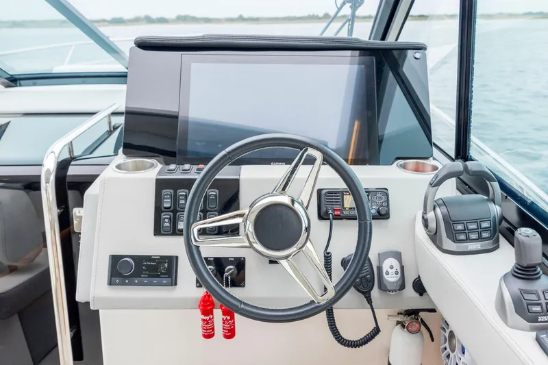 Slide: The Image of 2022 Regal 36 Grande Coupe helm with steering wheel, controls, and navigation display. - 32