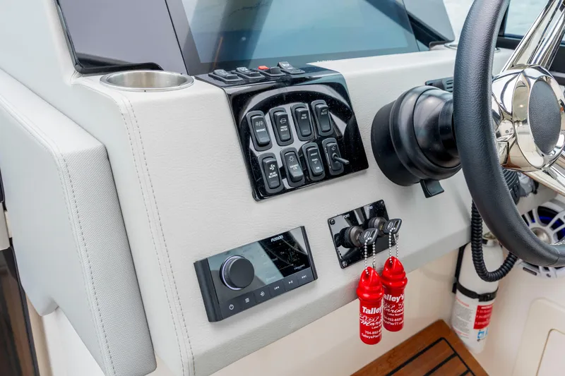 Slide: The Image of Control panel of 2022 Regal 36 Grande Coupe boat with steering wheel and switches. - 34