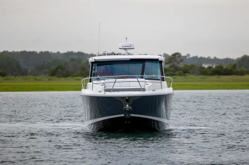 Slide: The Image of 2022 Regal 36 Grande Coupe cruising on calm waters, side view. - 5