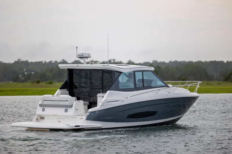 Slide: The Image of 2022 Regal 36 Grande Coupe cruising on a calm waterway. - 7