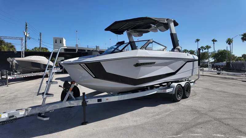 Slide: The Image of 2026 Nautique Paragon G23 boat on trailer under clear blue sky. - 10