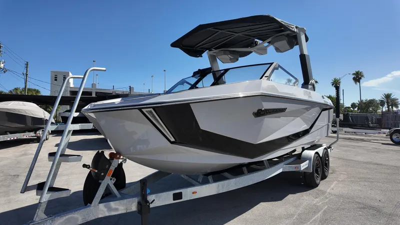 Slide: The Image of 2026 Nautique Paragon G23 boat on trailer under clear blue sky. - 12