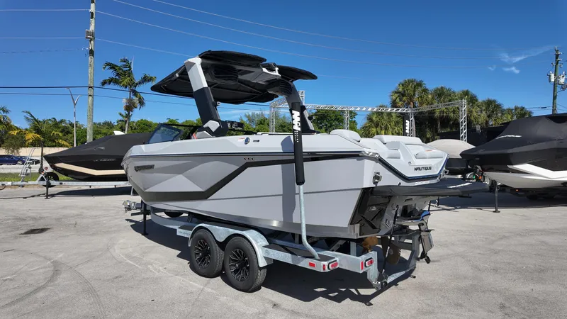 Slide: The Image of 2026 Nautique Paragon G23 boat on trailer, parked outdoors under clear blue sky. - 9