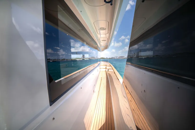 Slide: The Image of Side deck view of 2018 Sirena 64 yacht with ocean and cityscape in the background. - 19