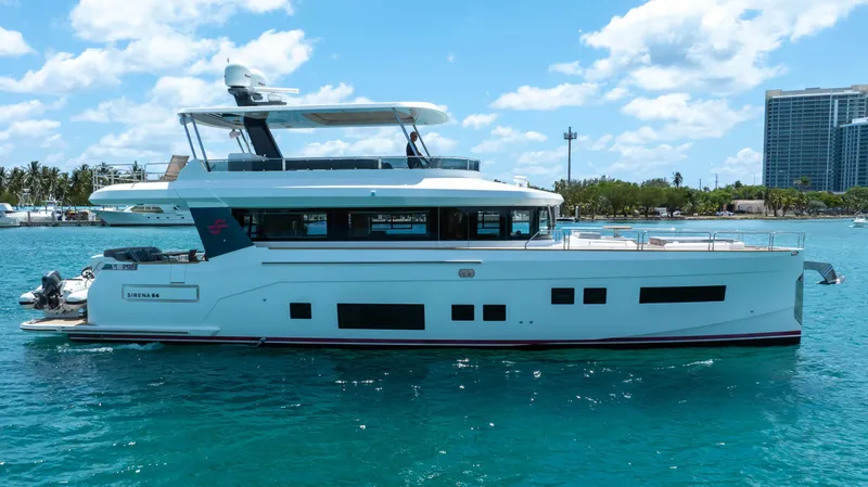 Slide: The Image of 2018 Sirena 64 yacht on clear blue water with cityscape background. - 3