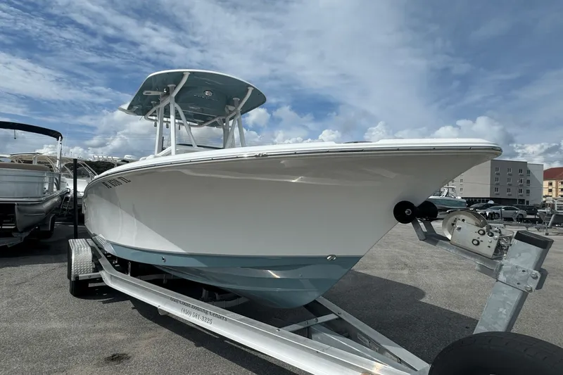 Slide: The Image of 2023 Sea Hunt 234 Ultra boat on trailer under a cloudy sky. - 0