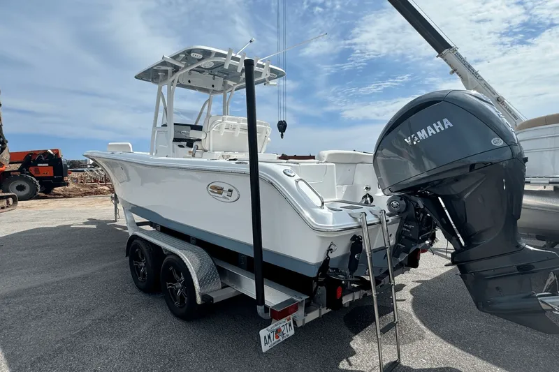 Slide: The Image of 2023 Sea Hunt 234 Ultra boat with Yamaha engine on trailer, parked outdoors. - 2