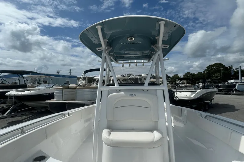 Slide: The Image of 2023 Sea Hunt 234 Ultra boat with T-top, docked under a cloudy sky. - 27