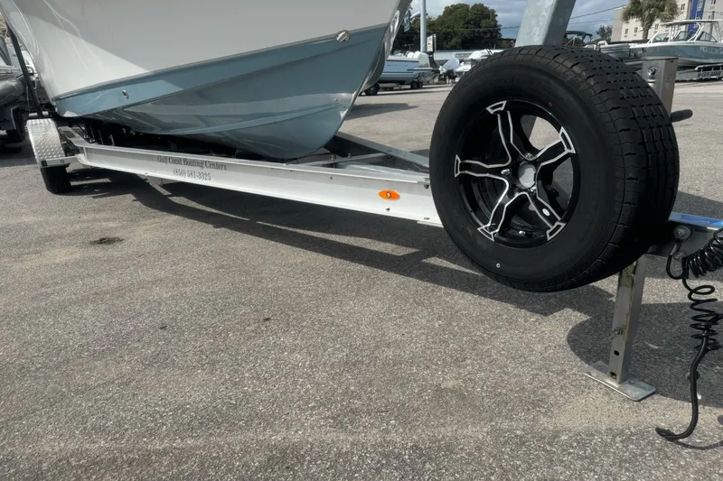 Slide: The Image of 2023 Sea Hunt 234 Ultra boat on trailer with black wheel, parked on asphalt. - 31