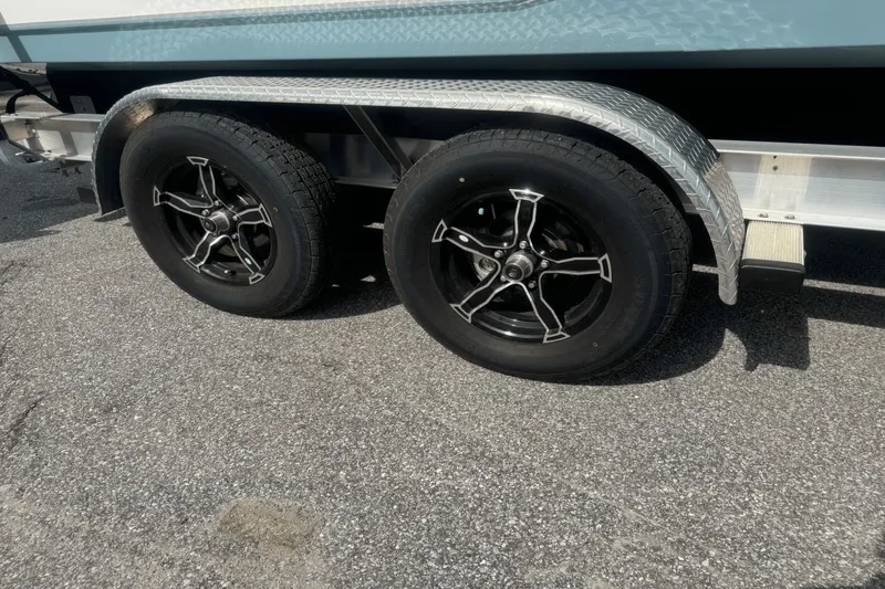 Slide: The Image of Trailer wheels of a 2023 Sea Hunt 234 Ultra boat on asphalt. - 32