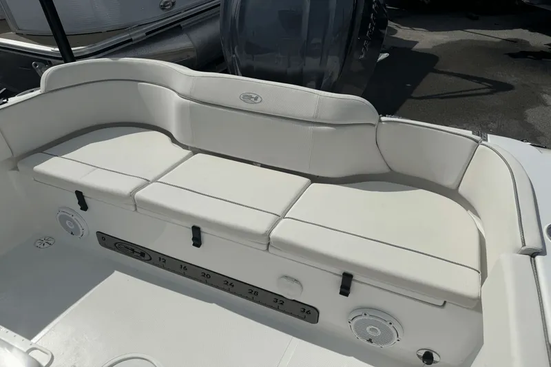 Slide: The Image of 2023 Sea Hunt 234 Ultra boat interior with white cushioned seating and built-in speakers. - 6