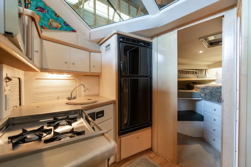 Slide: The Image of 1998 Carver 355 Aft Cabin interior with kitchen, stove, and cozy sleeping area. - 17