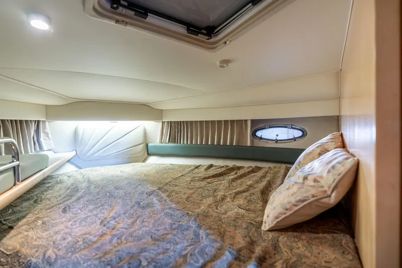 Slide: The Image of 1998 Carver 355 Aft Cabin interior with cozy bed and porthole window. - 21